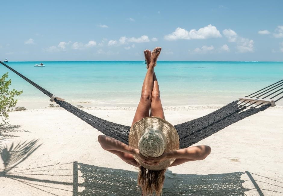 SANDFLIES AND WOMAN IN A HAMMOCK ON A TROPICAL BEACH