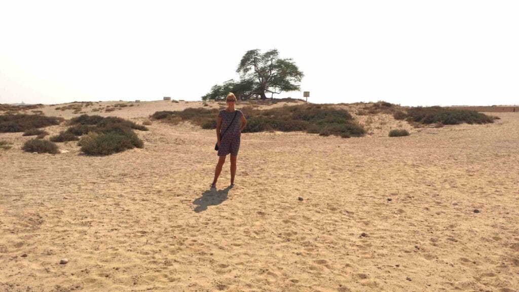 Janice Horton in front of the Tree of Life in the desert location Bahrain