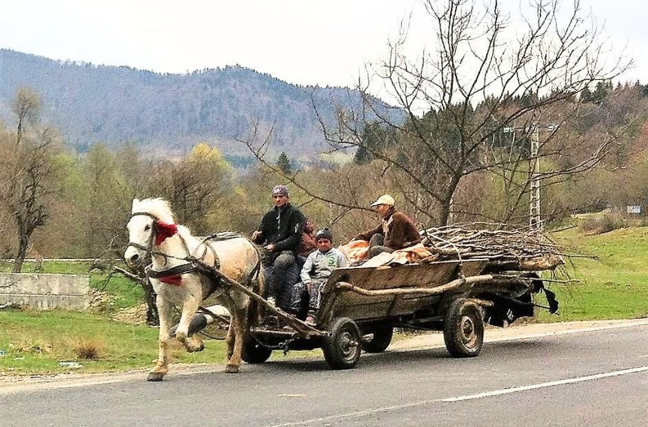 Romany people and horse-drawn carts on the roads alongside all the cars and trucks in rural Romania