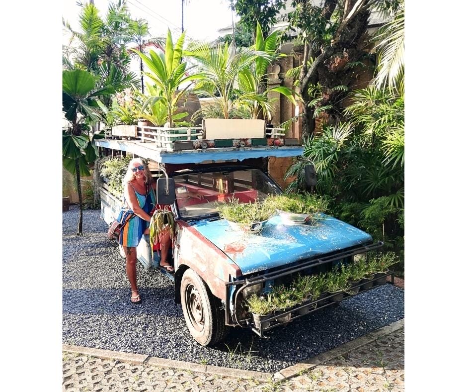 Janice Horton standing next to an old truck songthaew taxi in Phuket.